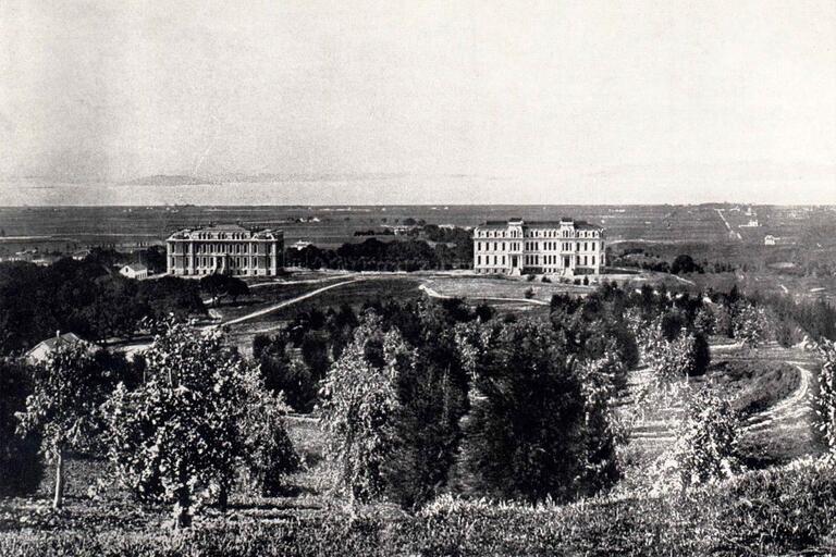 Historical photograph of campus from 1874; two large buildings are apparent