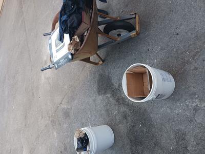 Buckets and a wheelbarrow holding trash